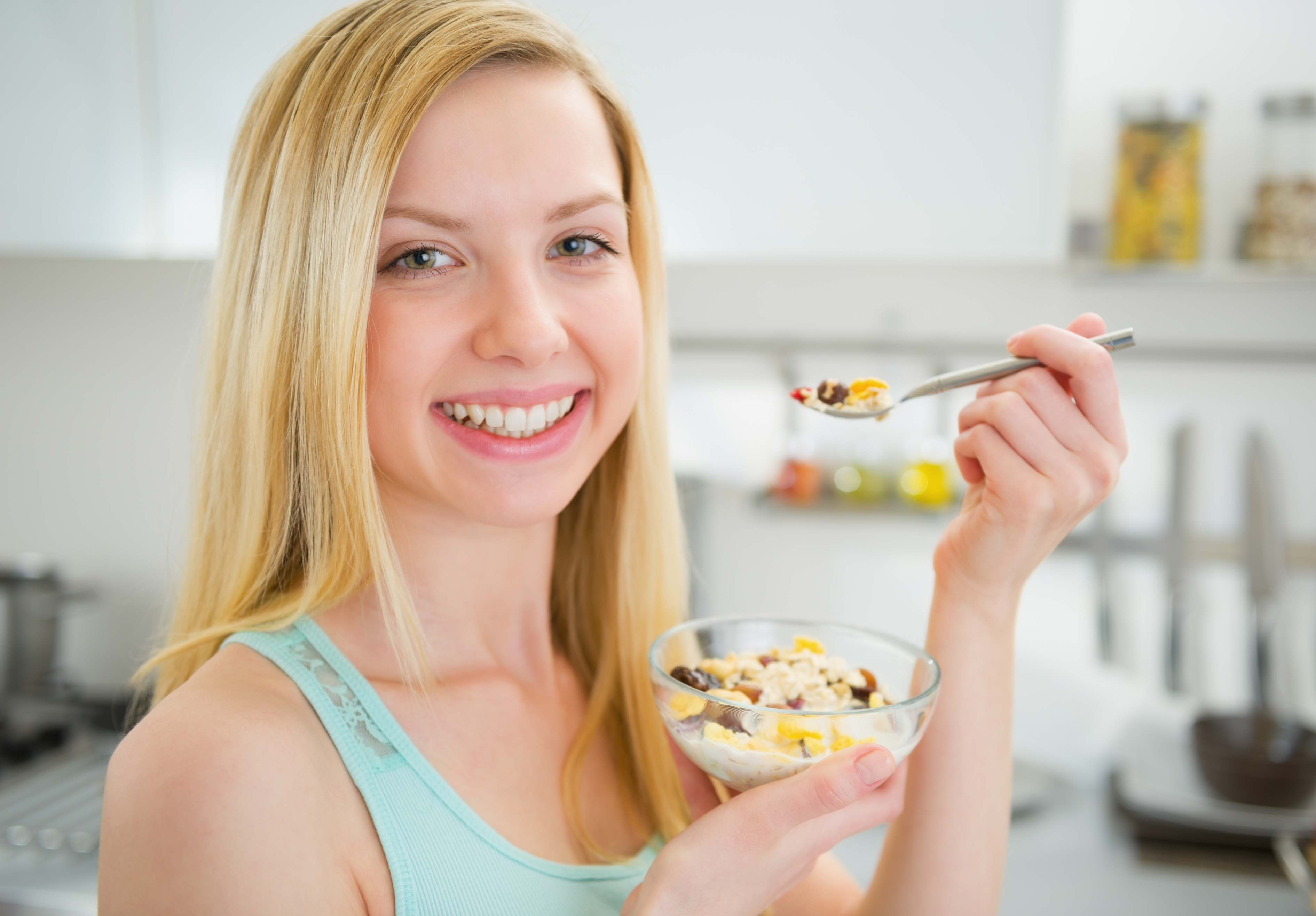 happy young woman eating healthy breakfast